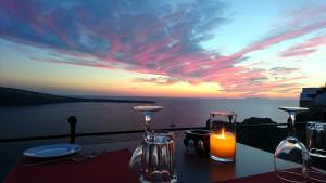 a table with a candle and a view of the ocean at Esperas in Oia