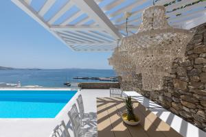 a large chandelier hangs from a stone wall next to a pool at Sealine Villas in Tourlos