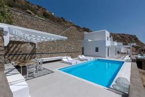 a villa with a swimming pool and a building at Sealine Villas in Tourlos