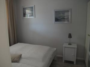 グリュックスブルクにあるFEWO Muschelのベッドルーム1室(ベッド1台、2枚の写真付きのナイトスタンド付)