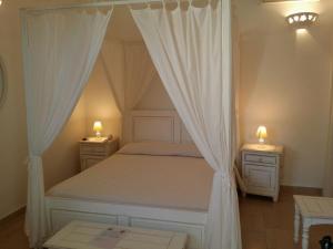 a bedroom with a canopy bed with two night stands at Antica Masseria Ficazzana - Tenuta in Marina di Pescoluse