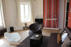 uma sala de estar com um sofá e uma cadeira em Maison Valmer - Le négociant, élégant F2 classé 4 étoiles em Le Havre