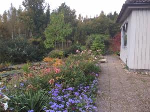 a garden with colorful flowers next to a building at Sibbarp in Näsum