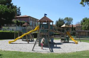two children playing in a playground with a slide at Apartma Izola in Izola