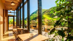 un restaurante con mesas y vistas a la montaña en Porta Caucasia Kazbegi, en Kazbegi