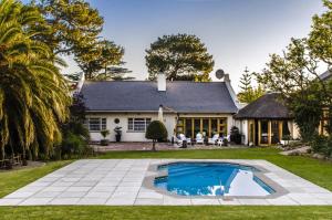 une maison avec une piscine dans la cour dans l'établissement KaapsePracht Bed & Breakfast, à Somerset West