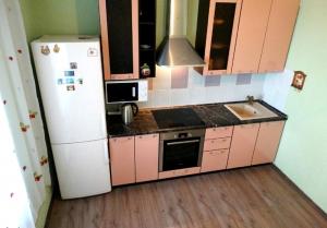 ポドリスクにあるInnDays 50лет ВЛКСМ 18のピンクのキャビネットと白い冷蔵庫付きのキッチンが備わります。