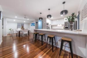 a kitchen with wooden floors and a counter with stools at Hayman Views in Airlie Beach