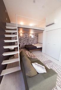 ein Wohnzimmer mit Sofa und Treppe in einem Zimmer in der Unterkunft AOCA Kaminoge 501 in Tokio