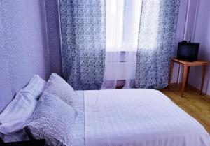 ポドリスクにあるInnDays 43 Армии 21のベッドルーム1室(青いカーテン、窓付)