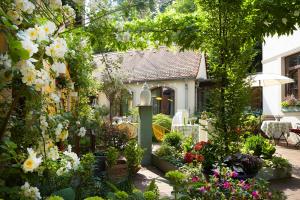 a garden in front of a house with flowers at Fährhaus Meißen B&B in Meißen