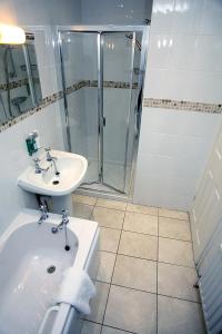a white bathroom with a sink and a shower at Devonshire Park Hotel in Eastbourne