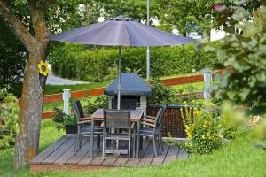 a table and chairs under an umbrella on a deck at Seeapart Pöder in Ladis