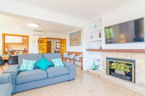 a living room with a blue couch and a fireplace at Cala Figuera in Cala Figuera