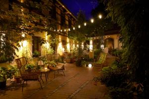 an outdoor patio with chairs and plants at night at Fährhaus Meißen B&B in Meißen