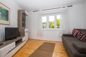 uma sala de estar com um sofá e uma janela em Madonna Field Apartment em Dubrovnik