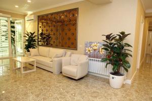 a living room with a couch and a potted plant at Rusel Hotel in Baku