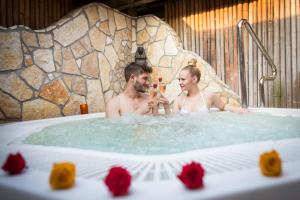 a man and woman in a hot tub at Korošec Apartments and Wellness Centre in Mozirje