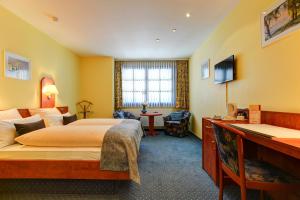 una camera d'albergo con letto e scrivania di Hotel Elbinsel ad Amburgo