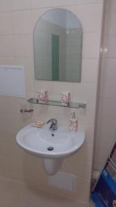 a bathroom with a white sink and a mirror at Apart hotel Sara seaview in Olimp +11 photos