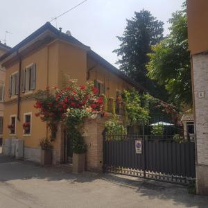 a house with a black fence and red flowers at Corte Delle Rose in Voghera