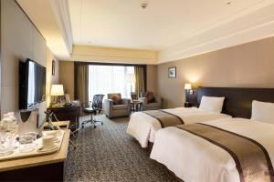 a hotel room with two beds and a television at Grand Forward Hotel in Taipei