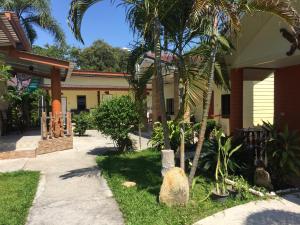 a house with a palm tree in the yard at Samet Bellhouse in Ko Samed
