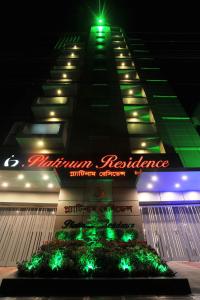 a tall building with a sign on it at night at Platinum Residence in Dhaka
