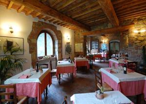 a restaurant with tables and chairs in a room at Hotel Giogliano in Radicondoli