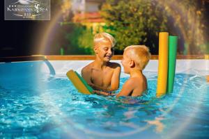 dois rapazes a brincar numa piscina em Karkonoski SPA - Bufet mini All Inclusive gratis! em Karpacz