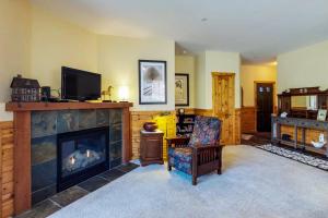 a living room with a fireplace and a tv at Boulders Hideout in Truckee