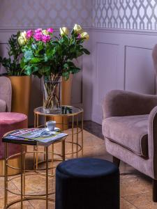 uma sala de estar com um sofá e uma mesa com flores em Hotel Cristal Park em Dąbrowa Tarnowska