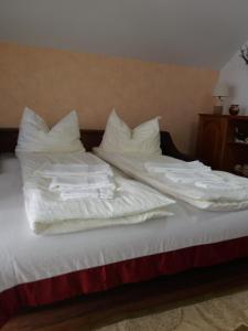a bed with white sheets and pillows on it at Casa Vlasea Albesti Sighișoara in Sighişoara