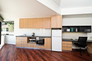 a kitchen with a stove top oven and a refrigerator at St Catherine's on Park in Perth