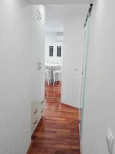 een kamer met witte muren, houten vloeren en een tafel bij Studio apartman Karolina in Karlovac