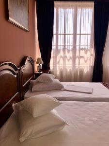two beds in a bedroom with a window at Hotel Rion in Mangalia