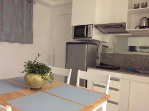 a kitchen with a table and chairs and a kitchen with a table and a table at Alta Residences in Locsin