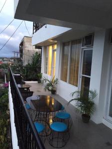 a patio with tables and chairs on a balcony at Alta Residences in Locsin