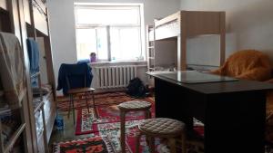 a kitchen with a counter and stools in a room at Happy Hostel in Kochkor in Kochkorka
