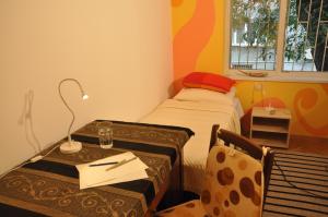 Habitación pequeña con cama y mesa con lámpara. en Arlequin Apartment, en Varna