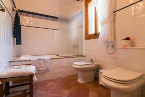 a bathroom with a toilet and a tub and a sink at Cocons in Sineu +32 photos