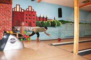 a man playing a game of bowling in a bowling alley at Zum Schlossgarten in Ralswiek