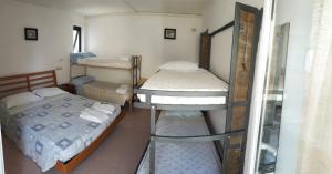 a small room with two bunk beds and a mirror at Atene Albergo Riccione in Riccione