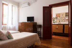 a bedroom with a bed and a dresser and a television at La Casa delle Zie in Cologna Veneta