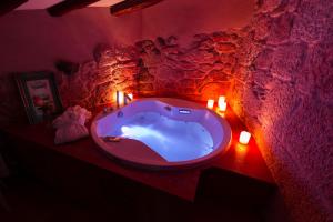 bañera roja en una habitación con velas en O Remanso Dos Patos en Penalba