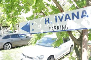 un coche blanco estacionado junto a un letrero de la calle en Hotel Ivana, en Misano Adriatico