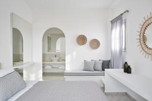 a white bedroom with a bed and a mirror at Mrs. Armelina by Mr&Mrs White Hotels in Naousa