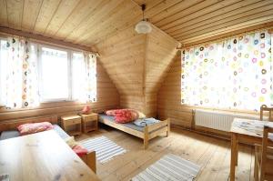 ザコパネにあるCountry Home in heart of Tatra mountainsの木造家屋 ベッド2台付きの部屋