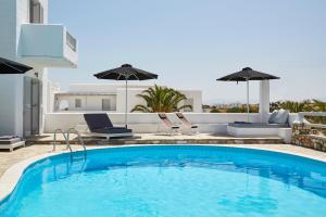 a swimming pool with two chairs and an umbrella at Mrs. Armelina by Mr&Mrs White Hotels in Naousa