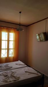 a bed in a room with a window at Markos Village Pension in Ios Chora